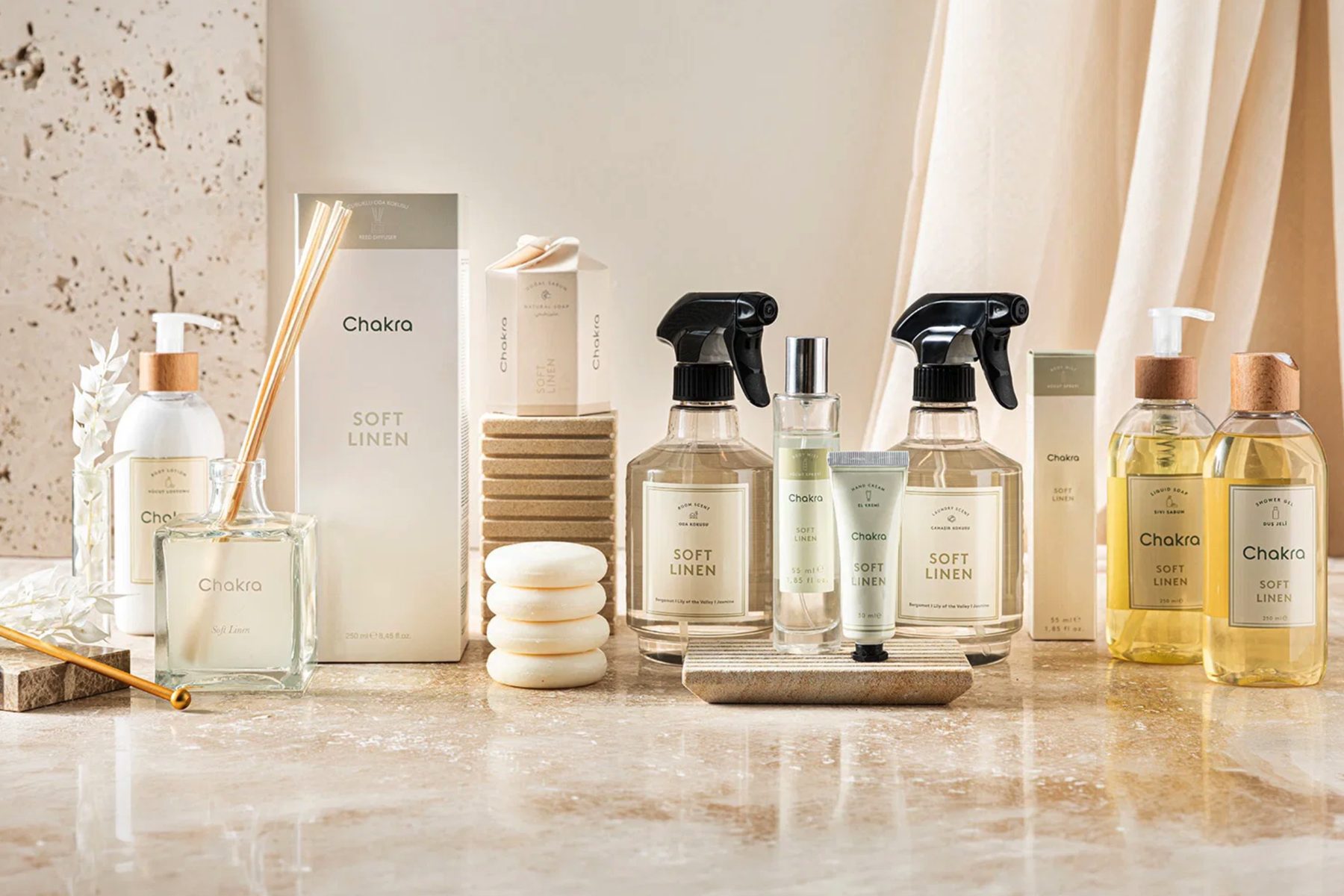 Bath and home-fragrance range — reed diffuser, soaps, hand cream, liquid soap and shower gel — on a marble counter